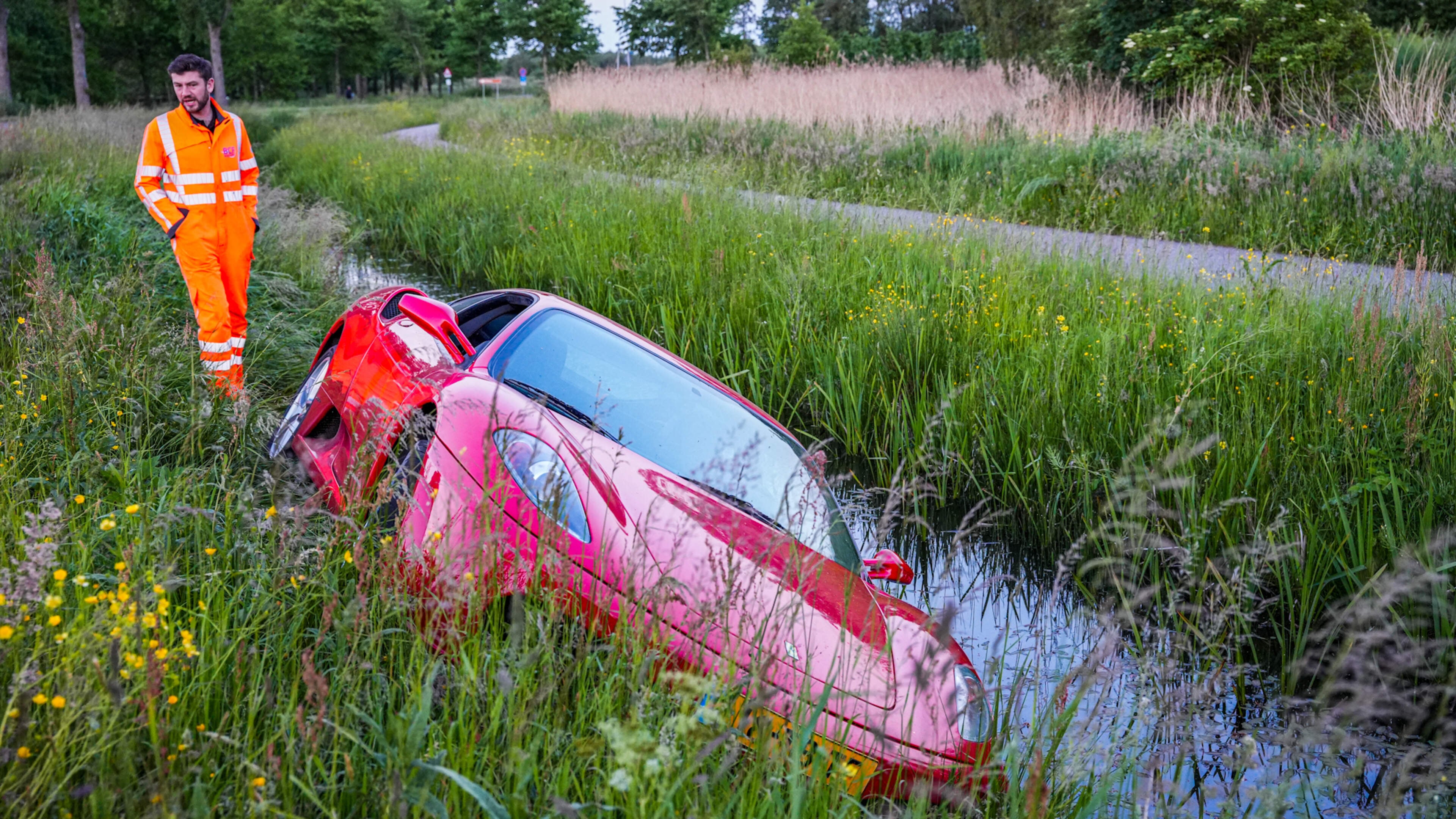 Peperdure Ferrari glijdt van de weg en rijdt sloot in: bestuurder ontsnapt aan duik