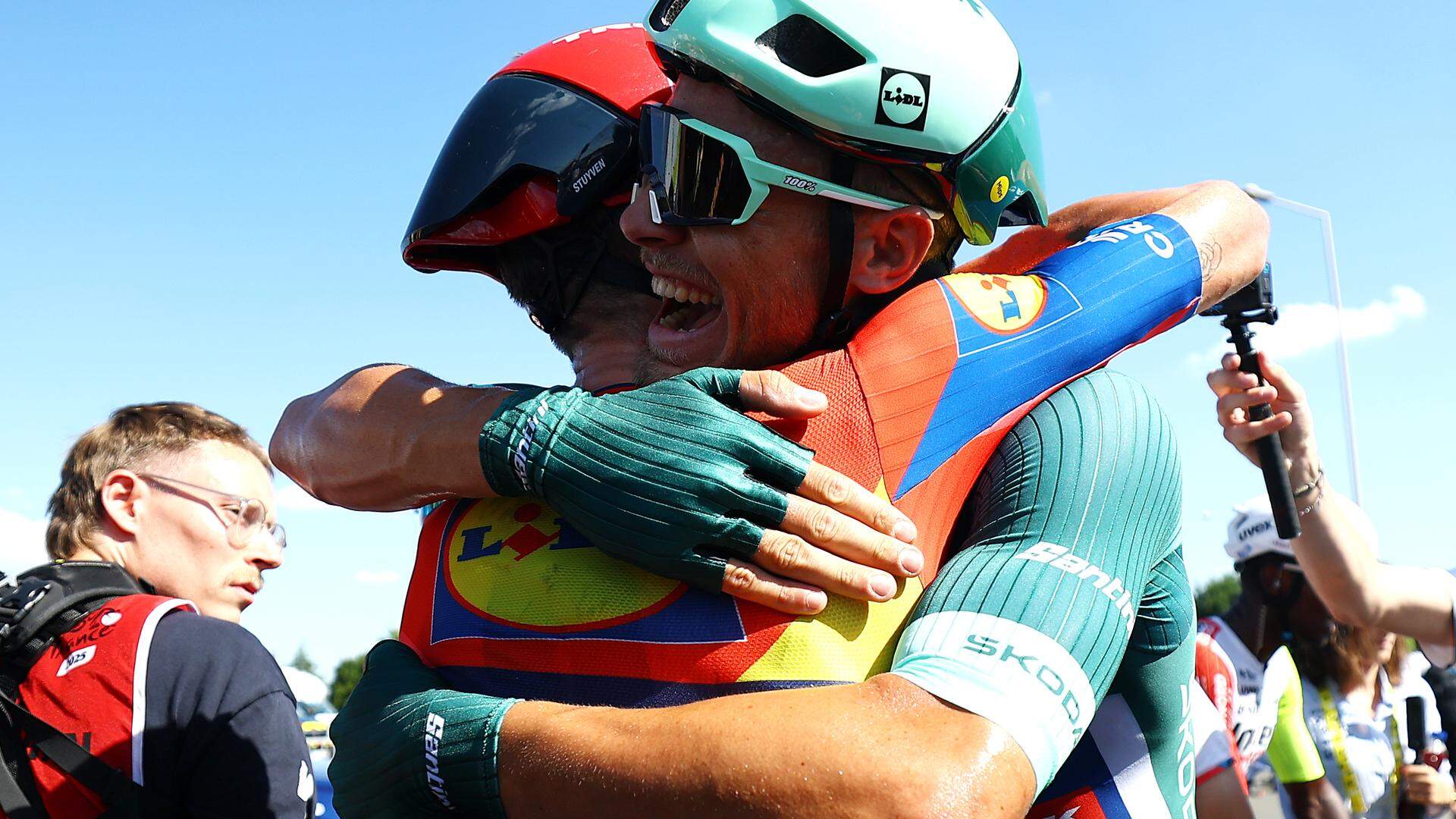 Jasper Stuyven viert feest met ritwinnaar Jonathan Milan.