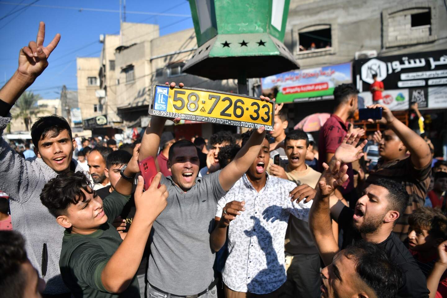 Palestijnen in Gaza tonen een Israëlische kentekenplaat, buitgemaakt op 7 oktober 2023.