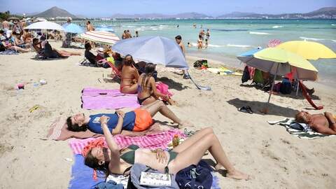 Toeristen op het strand van Alcudia op Mallorca.